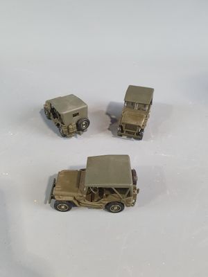 four toy army vehicles that are sitting on a white surface