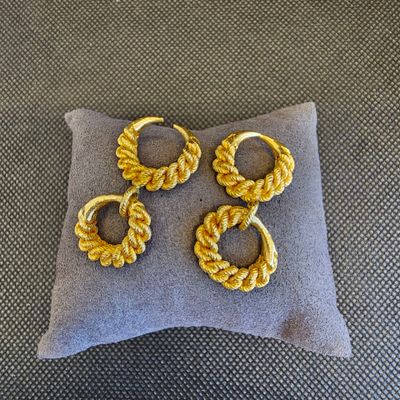 un gros plan sur un oreiller sur lequel repose une paire de boucles d'oreilles