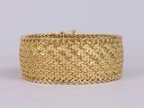 a close up of a gold bracelet on a white background