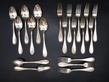 many forks and spoons laid out on the table