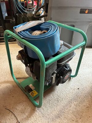 un chariot vert surmonté d'un tuyau bleu