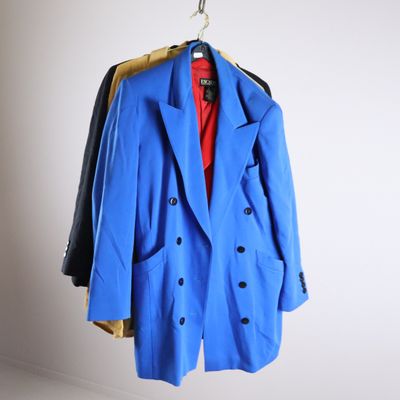 a blue coat hanging on a hanger in a room