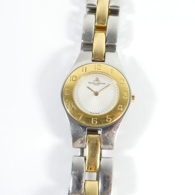 une image d'un gros plan d'une montre-bracelet sur une surface blanche