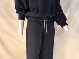 Le mannequin porte un sweat-shirt et un pantalon noirs.