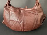 a close up of a brown leather purse on a table