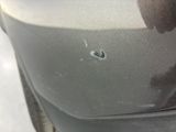 the front bumper of a car with a bullet hole in it