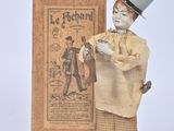 a small figurine of a man with a top hat and cane