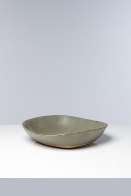 un bol vert posé sur une table blanche