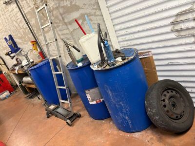 trois fûts bleus et une roue dans un garage