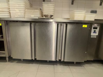 une cuisine en inox avec beaucoup de vaisselle sur le plan de travail
