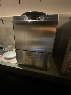 a stainless steel dishwasher sitting on a counter in a kitchen