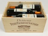 bottles of wine in a wooden box on a white surface