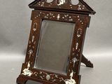 a small mirror with a wooden frame on a stand