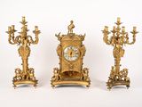 three gold colored clocks sitting next to each other on a white surface
