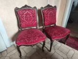 two red chairs sitting next to each other on a tiled floor