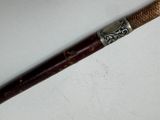a wooden stick with a metal handle on a white surface