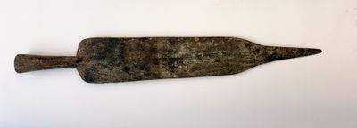 une pagaie en bois posée sur une surface blanche
