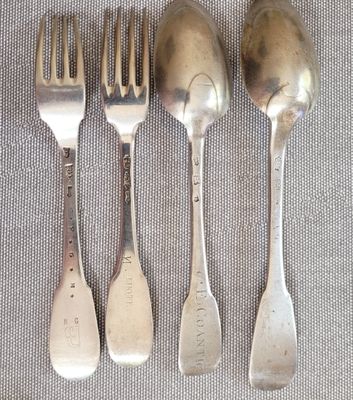 quatre cuillères en argent et deux cuillères en argent sur une table