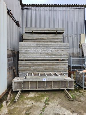 a large pile of wooden planks in front of a building