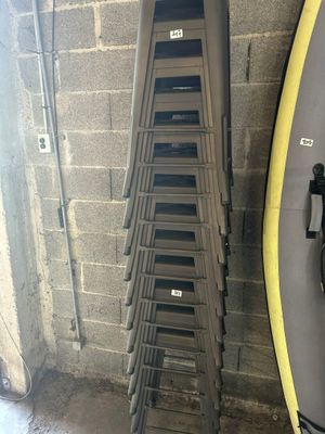 une pile de planches de surf à côté d'un support à pagaies
