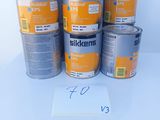 six tins of silkkene paint on a white surface