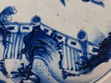 a blue and white plate with birds and flowers on it