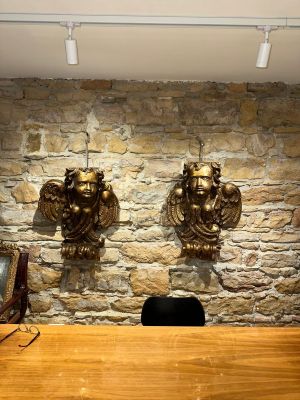 two wall sconces on the stone wall above a desk