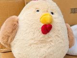 a stuffed chicken sitting on top of a cardboard box