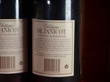two bottles of wine sitting on top of a table next to each other