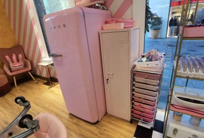 a pink refrigerator and a pink chair in a room