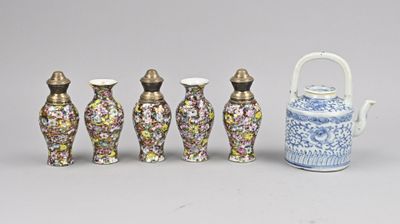 Plusieurs vases et une théière sont alignés en rang