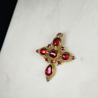 une image montrant un gros plan d'une broche rouge et dorée