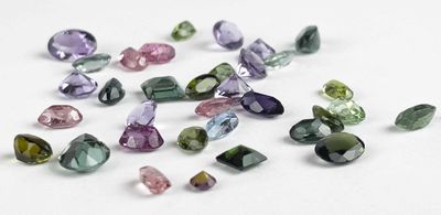 multi - colored tourmaline gems on a white surface