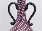 striped glass vase with black handles on a white background