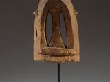 an image of a wooden sculpture of a face on a stand