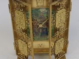 a gold clock with a picture of a man and woman on it