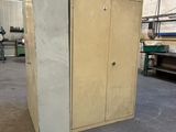 une armoire au milieu d'un entrepôt, dont la porte est ouverte