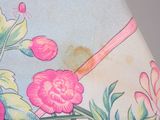 a close up of a lamp shade with flowers on it