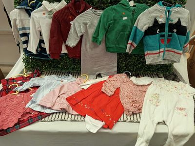 beaucoup de vêtements pour bébés exposés sur une table