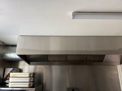 une cuisine équipée d'une cuisinière et d'une hotte aspirante