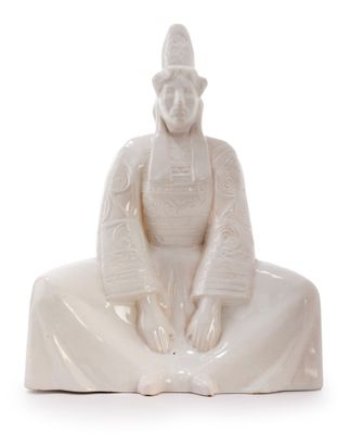 statue of a woman sitting on a white surface with a white background