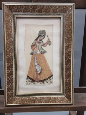 tableau représentant une femme tenant une cruche d'eau, dans un cadre en bois