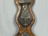 une horloge en métal et en bois exposée sur un fond blanc
