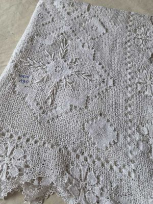un gros plan d'une couverture tricotée blanche posée sur une table