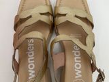 the woman ' s sandals are made of leather and have two straps