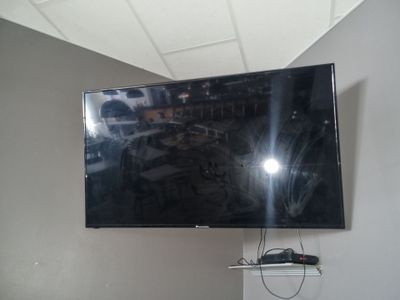 une télévision à écran plat fixée au mur au-dessus d'une étagère