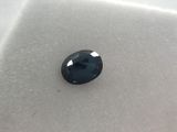 a close up of a black diamond on a white surface