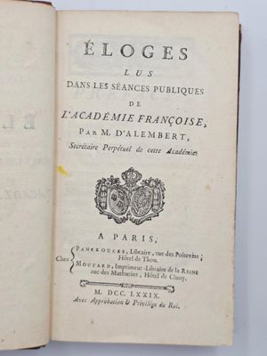 un livre ouvert sur lequel figure un blason