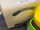 a yellow and green blender sitting next to a plastic container