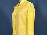 yellow shirt on a mannequin stand against a blue wall